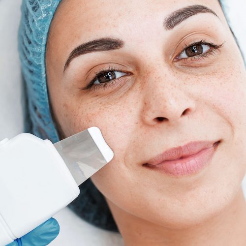 Portrait of a young beautiful girl. Cosmetic face cleaning with ultrasonic scrubber. Face care and rejuvenation behandling skin scrubber ultrasonic borås