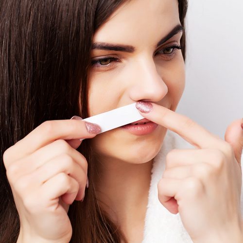 Care concept, woman holding stripe with wax to remove facial hair vaxning av mustasch